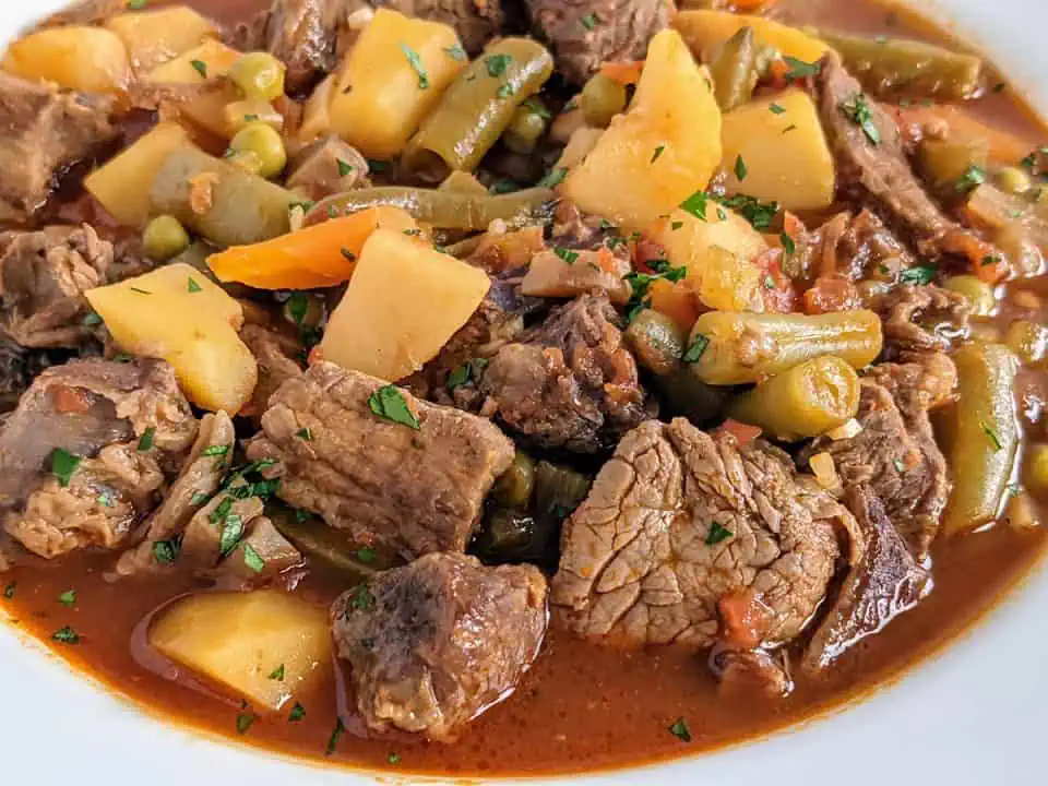 A white bowl full of Instant Pot vegetable beef soup.