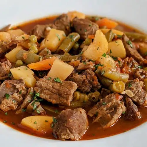 A white bowl full of Instant Pot vegetable beef soup.