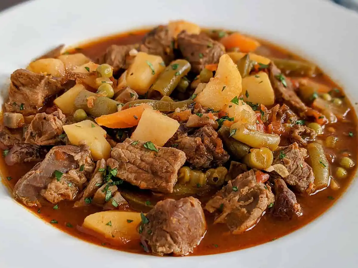 A white bowl full of Instant Pot vegetable beef soup.