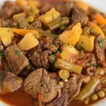 A white bowl full of Instant Pot vegetable beef soup.