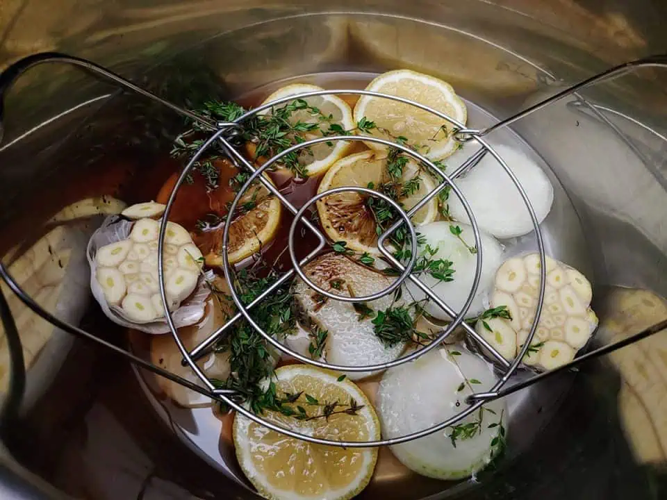 Aromatics in bottom of pot with water and trivet.