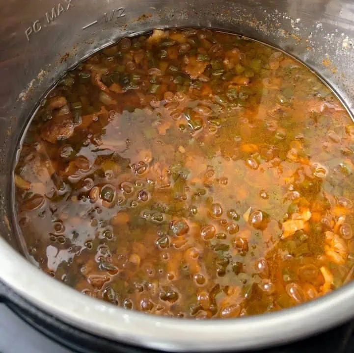 Baked beans cooking in a pressure cooker.