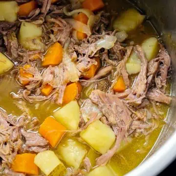 An Instant Pot filled pot roast, showing tender beef and chunks of potatoes and carrots.