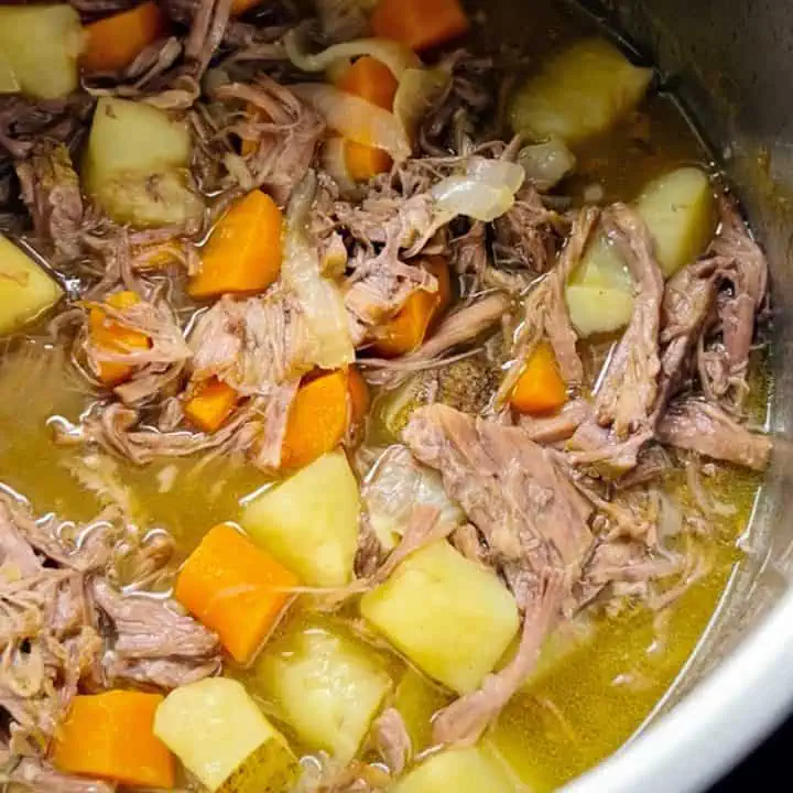 An Instant Pot filled pot roast, showing tender beef and chunks of potatoes and carrots.