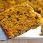 Closeup of a slice of Southern cornbread dressing on a spatula.