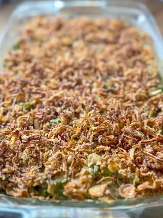 A casserole dish filled with green beans topped with crispy onions, ready to be served.