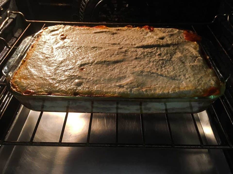 A casserole dish placed in the oven and beginning to cook.