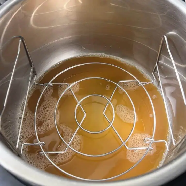 Apple cider and trivet inside of an Instant Pot.