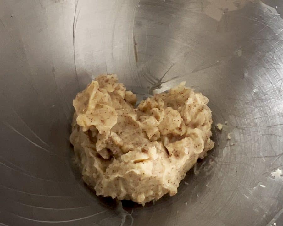 Cooled brown butter in the bottom of a stand mixer bowl, slightly solidified and speckled from toasting.