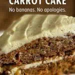 Close-up of a slice of Hummingbird Carrot Cake with cream cheese frosting on a white plate