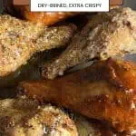 Closeup of extra-crispy, dry-brined air fryer chicken drumsticks on a gray plate with glossy sauce and pepper flecks.