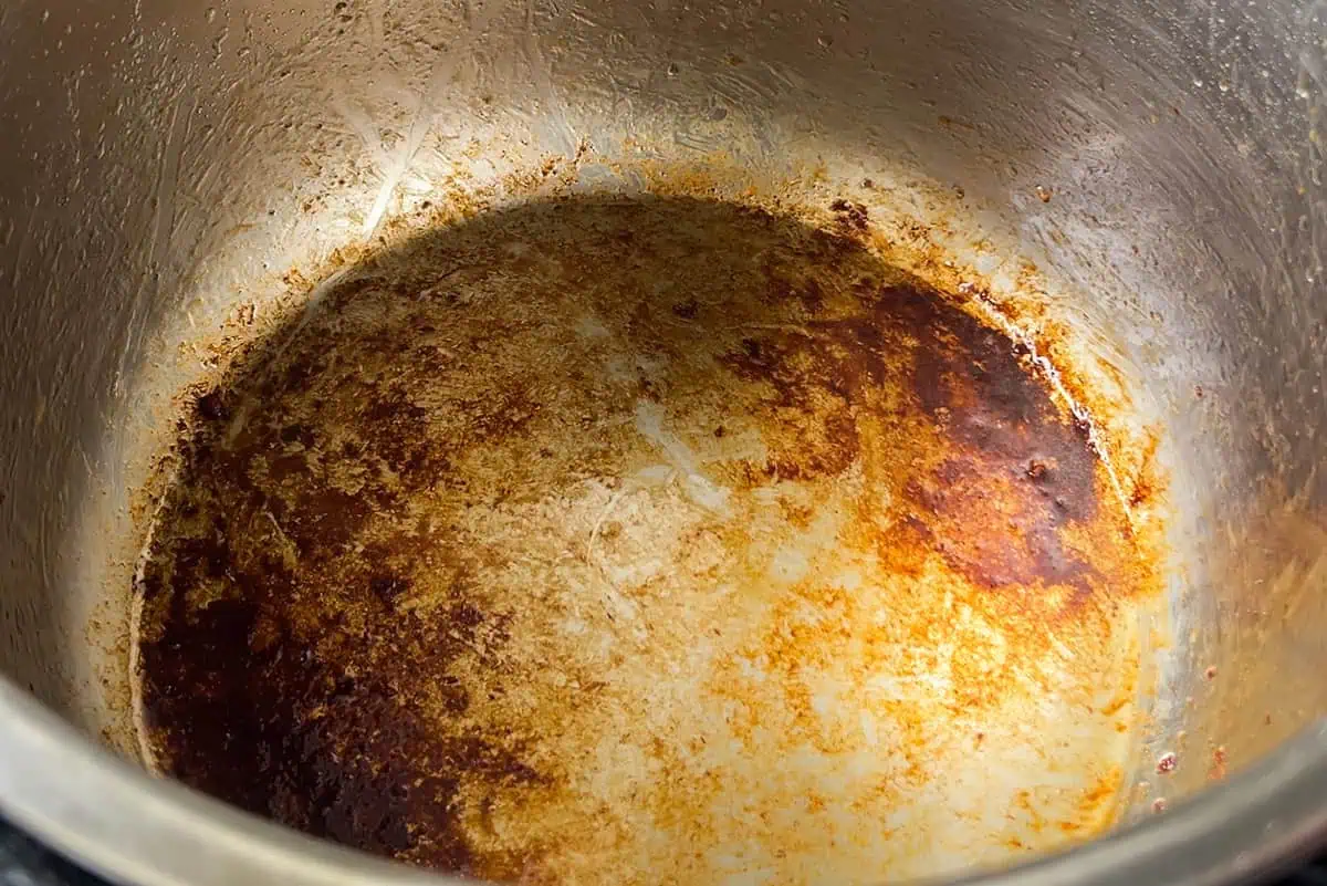 Golden-brown fond at the bottom of the Instant Pot after searing beef