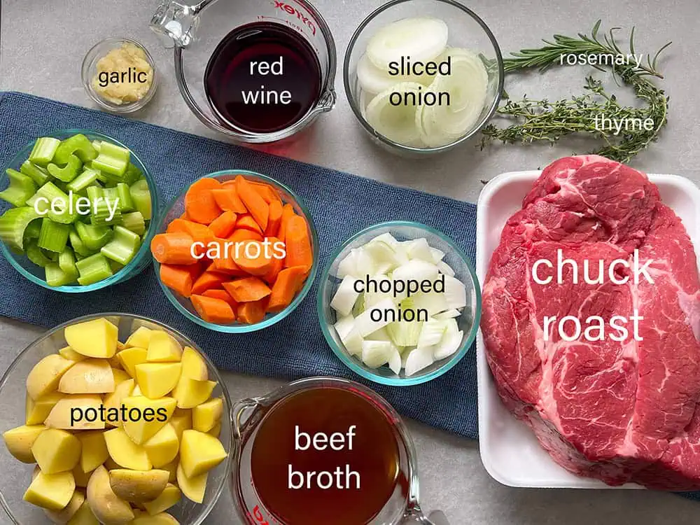 Labeled ingredients for Instant Pot pot roast: chuck roast, garlic, red wine, onions, celery, carrots, potatoes, beef broth, rosemary, and thyme.