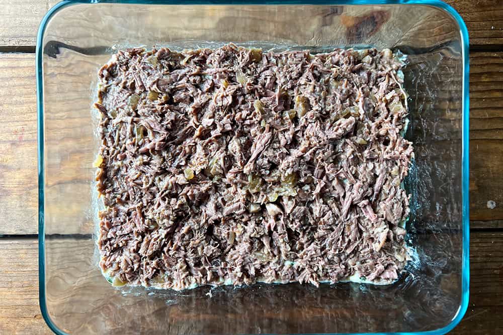 Shredded pot roast spread in an even layer over the ricotta.