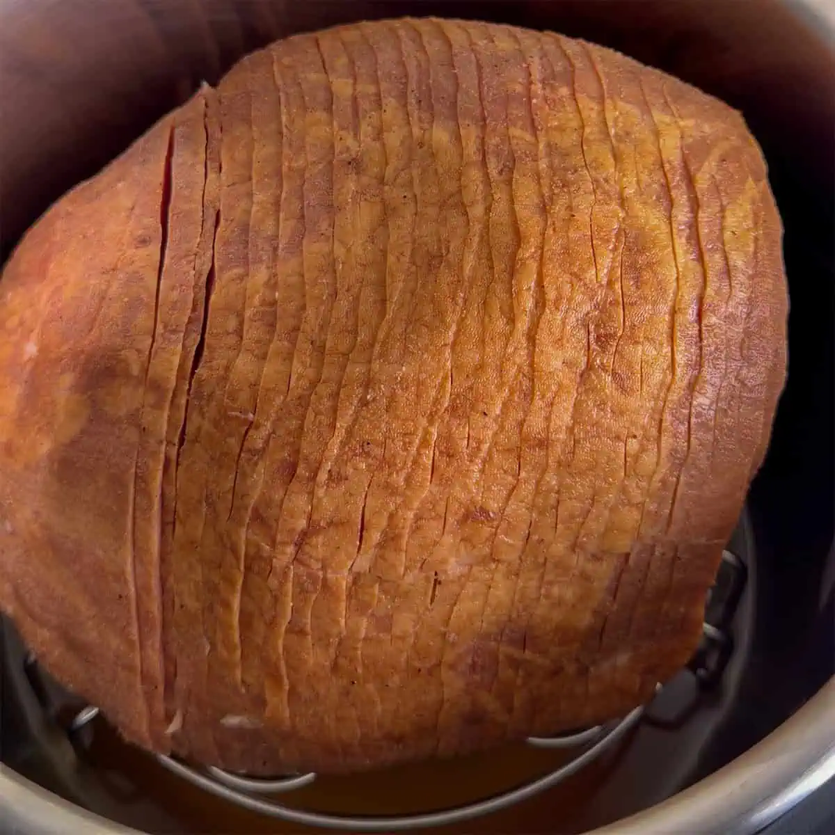 Spiral-cut ham placed on a trivet in the Instant Pot before warming.