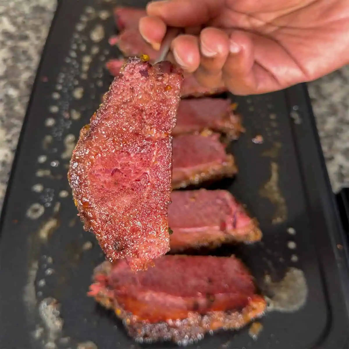 Crispy slice of leftover corned beef ready for Gary Reuben sandwiches