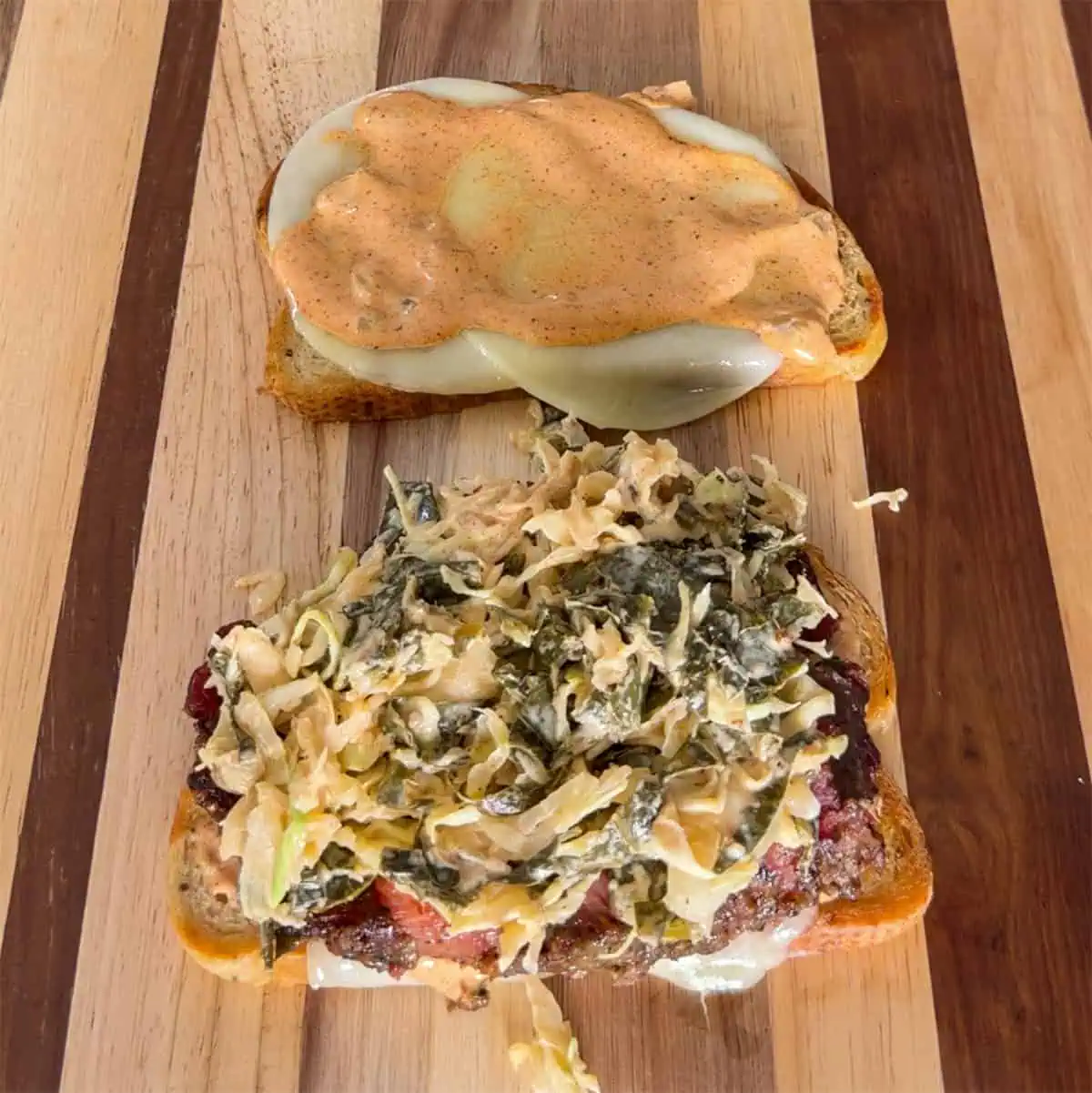 Open-faced Gary Reuben with crispy corned beef, slaw, melted cheese, and sauce on grilled bread
