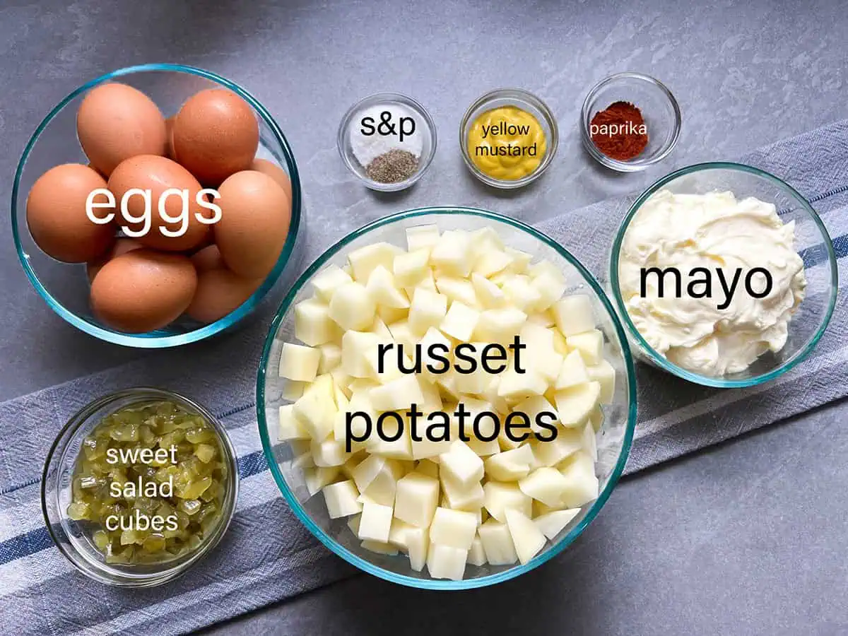 Ingredients for Instant Pot potato salad including russet potatoes, eggs, mayo, sweet salad cubes, mustard, paprika, salt, and pepper.