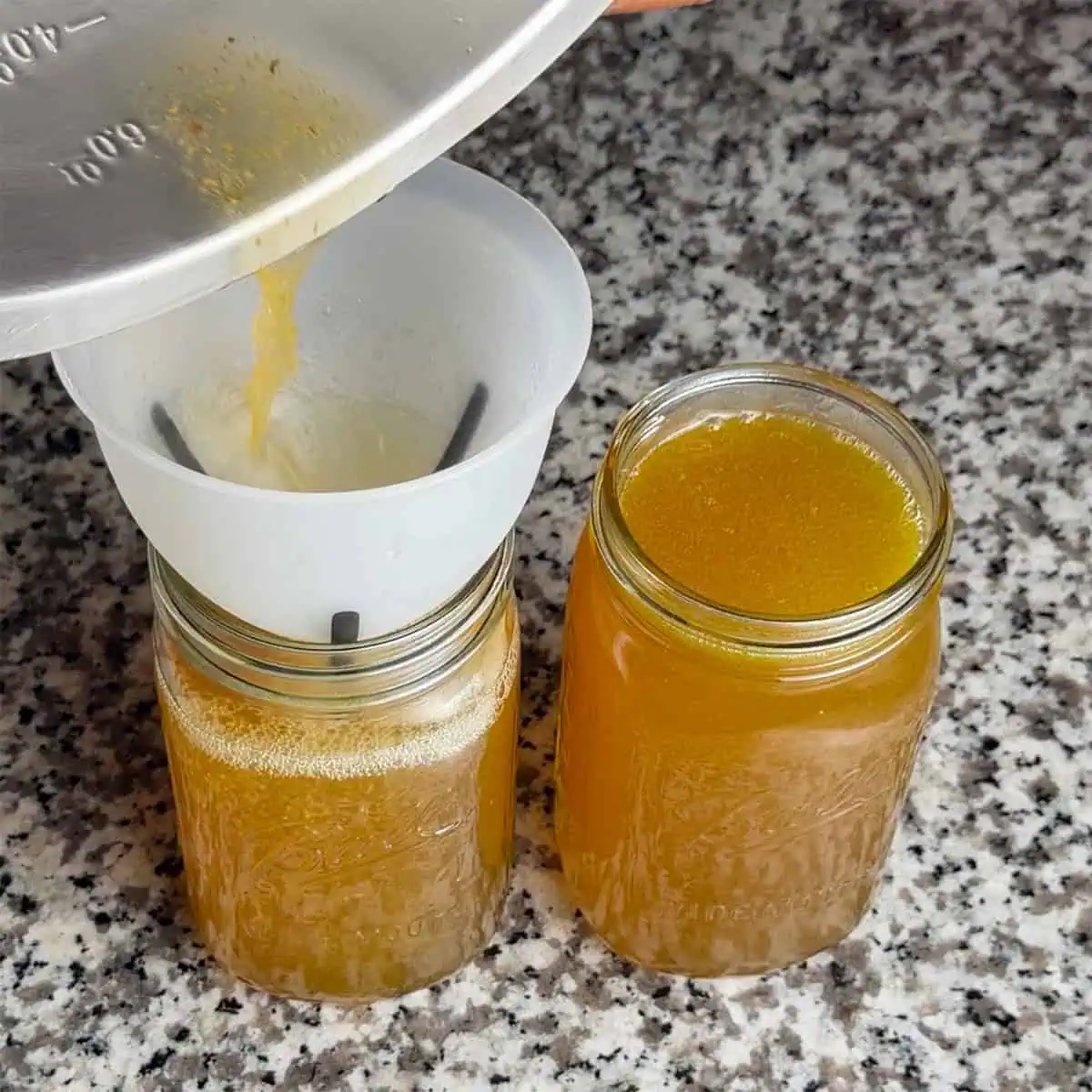 Extra pot liquor from collard greens being poured into mason jars for later use