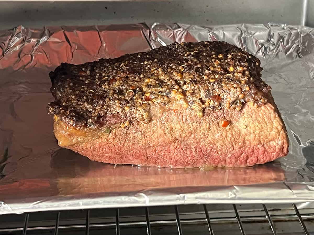 Slow cooker corned beef transferred to a foil-lined sheet pan after broiling to crisp the garlic-spice topping.
