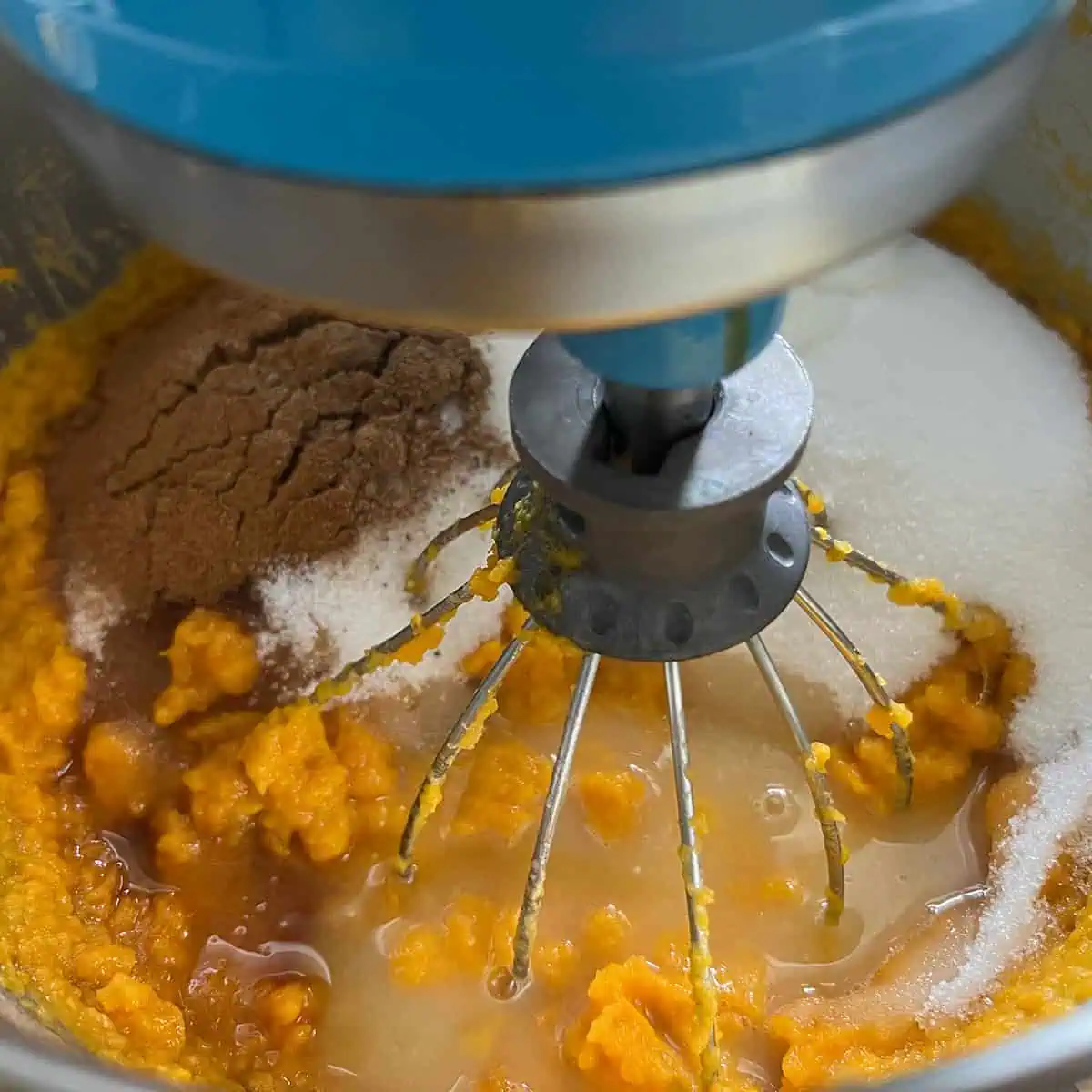 Sweet potato mixture in a stand mixer with sugar, spices, evaporated milk, lemon juice, and extracts added.