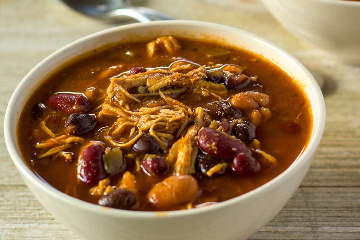 Instant Pot chicken chili with shredded chicken, beans, and rich tomato broth