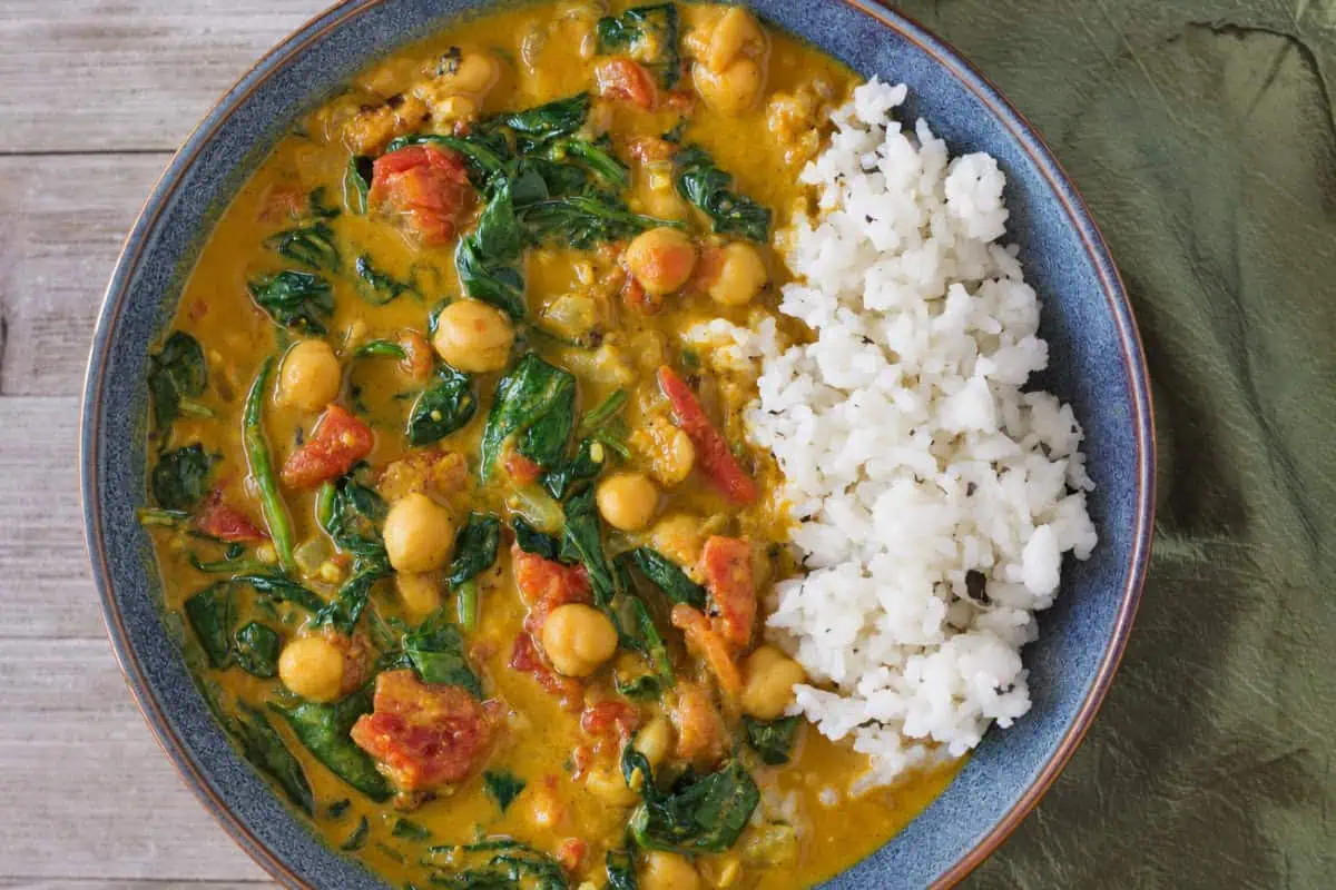 Bowl of Instant Pot chickpea curry with tomatoes, spinach, and rice.