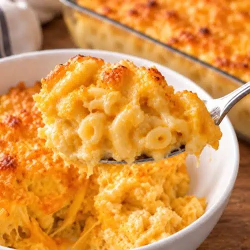 Creamy Southern baked mac and cheese on a serving spoon with a golden baked cheese crust