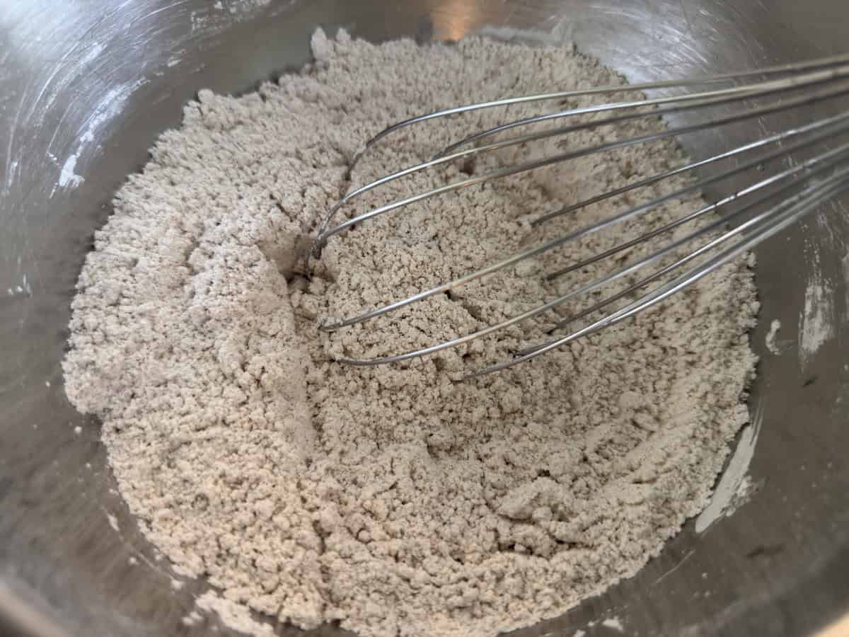 Gluten-free flour and spices whisked together in a mixing bowl.
