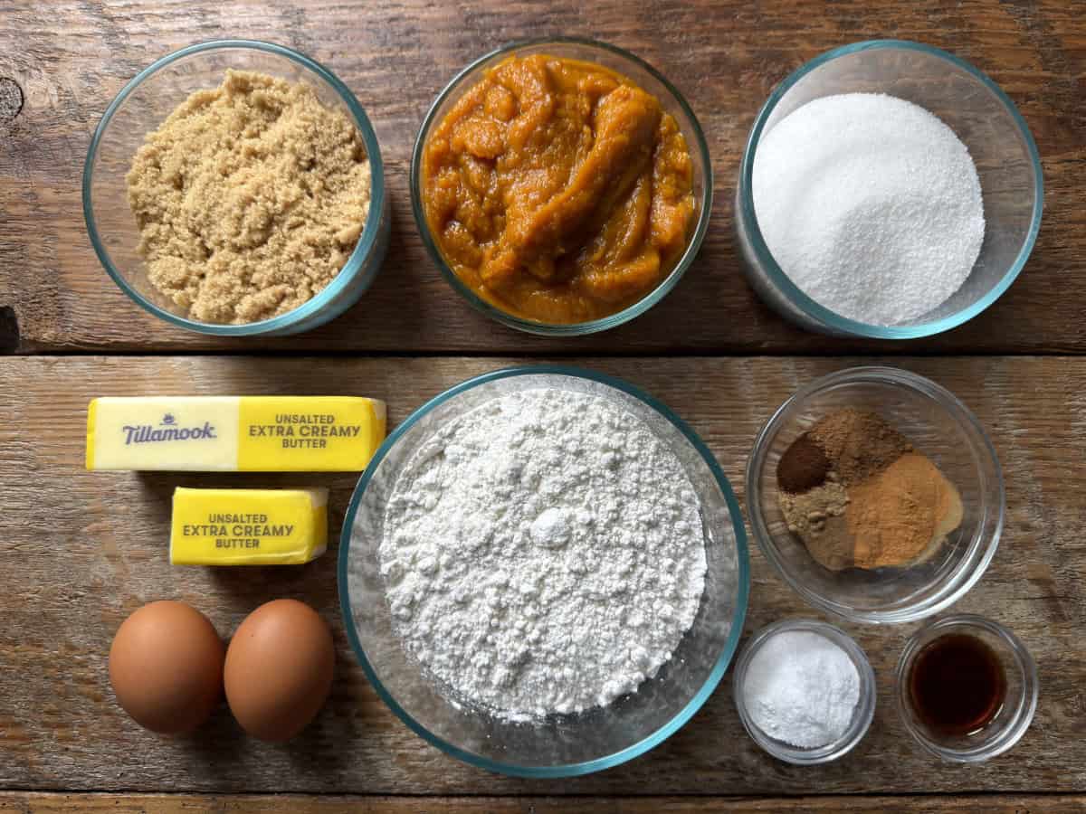 Ingredients for gluten-free pumpkin bread, including flour, pumpkin puree, brown and white sugar, butter, eggs, spices, vanilla, and baking powder.