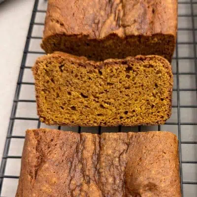 Close-up of sliced gluten-free pumpkin bread showing the soft, moist crumb and browned crust.