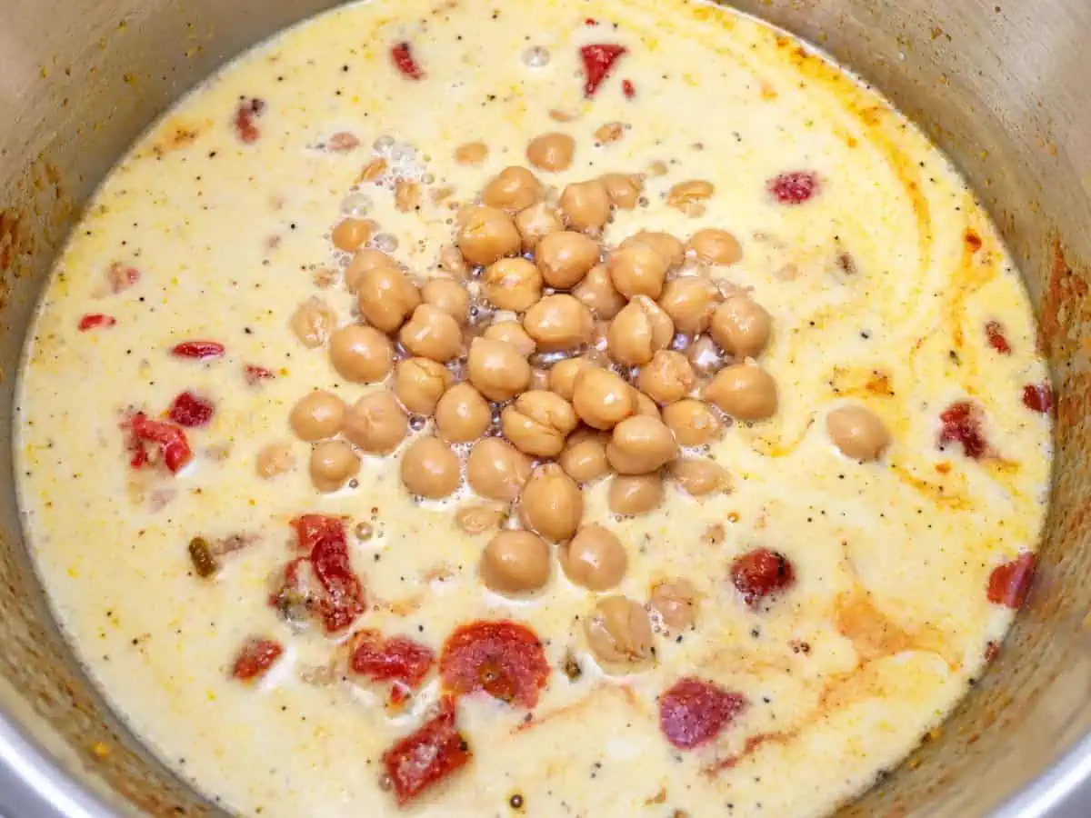 Chickpeas and coconut milk added to the tomato curry mixture in the Instant Pot.