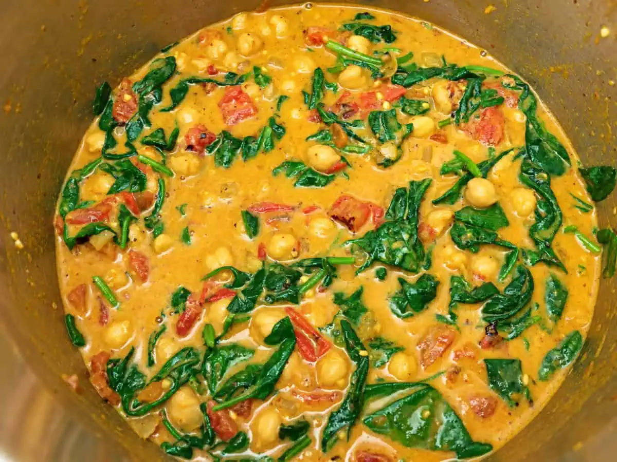 Finished chickpea curry with tomatoes and wilted spinach in the Instant Pot.