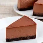 Close view of a chocolate cheesecake slice showing its creamy filling and dark crumb crust.